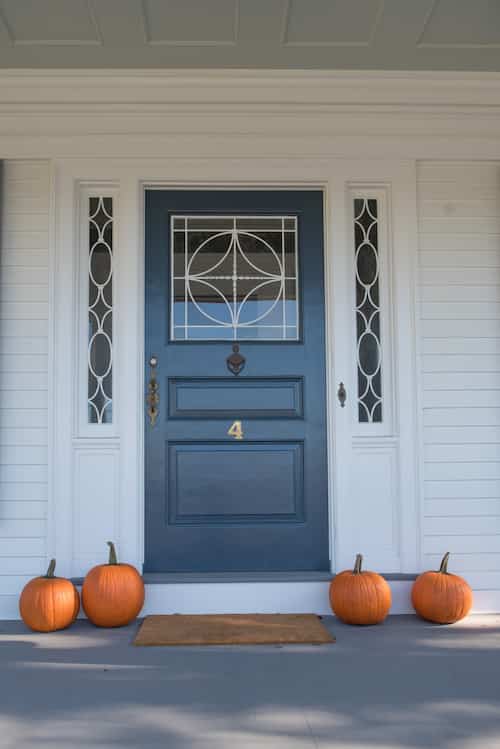 A blue front door adorned with pumpkins on the porch at Margin Street Inn.