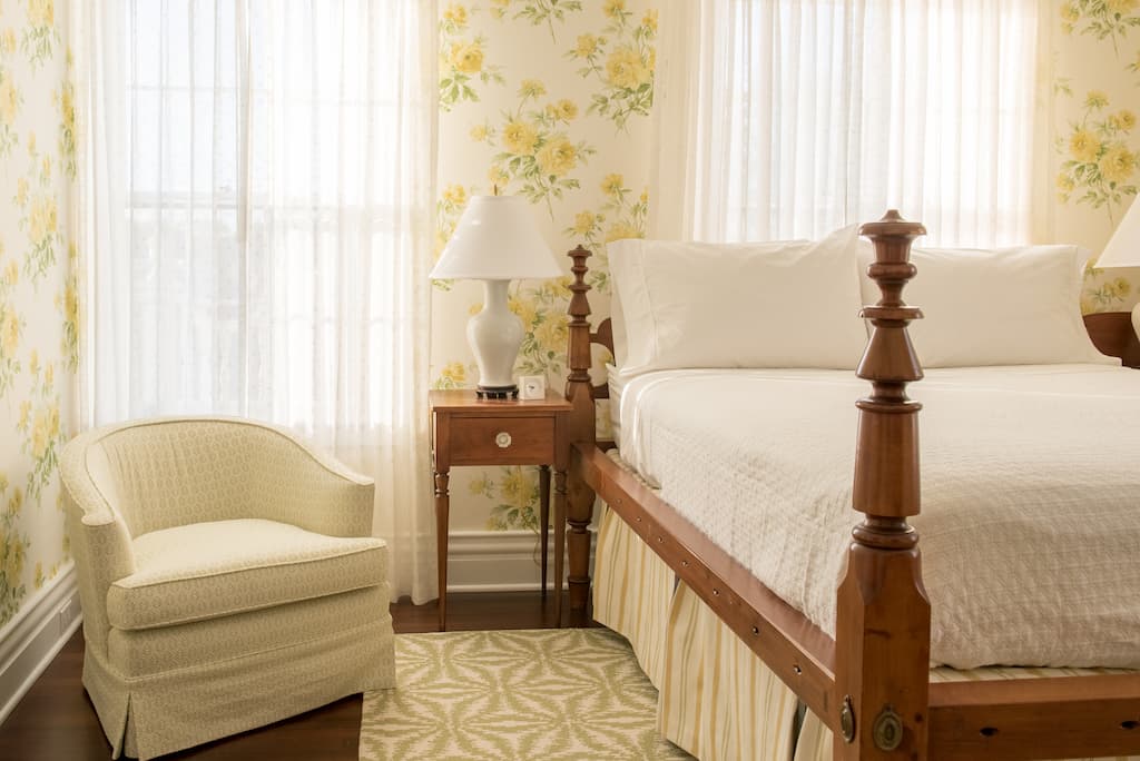 Bed, chair and desk lamp in The Yellow Floral room in Westerly, RI