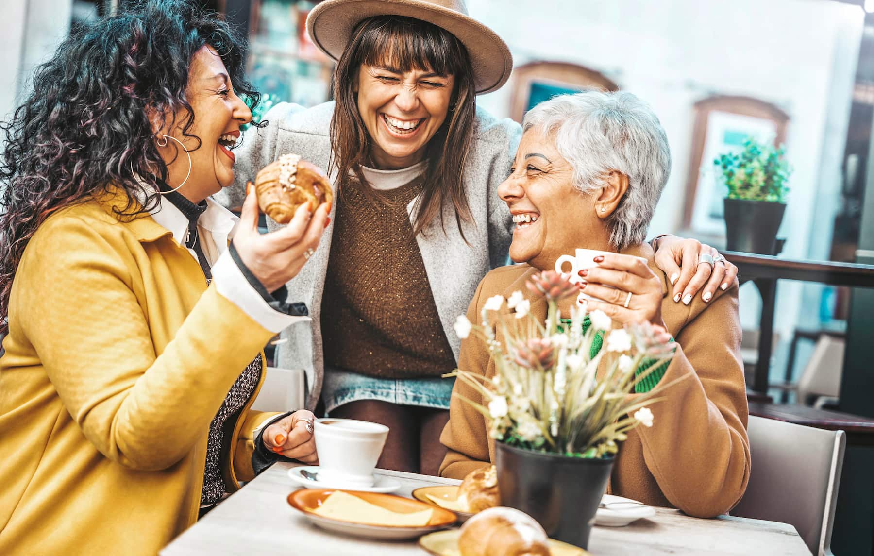 A group of women having fun at a coffee shop during a girls weekend getaway in New England