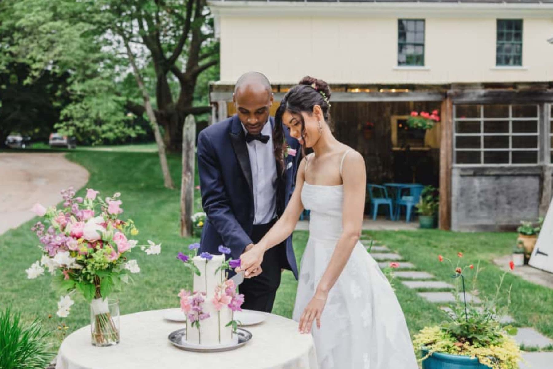 A bride and groom cutting into their wedding cake during their micro wedding at our New England bed and breakfast