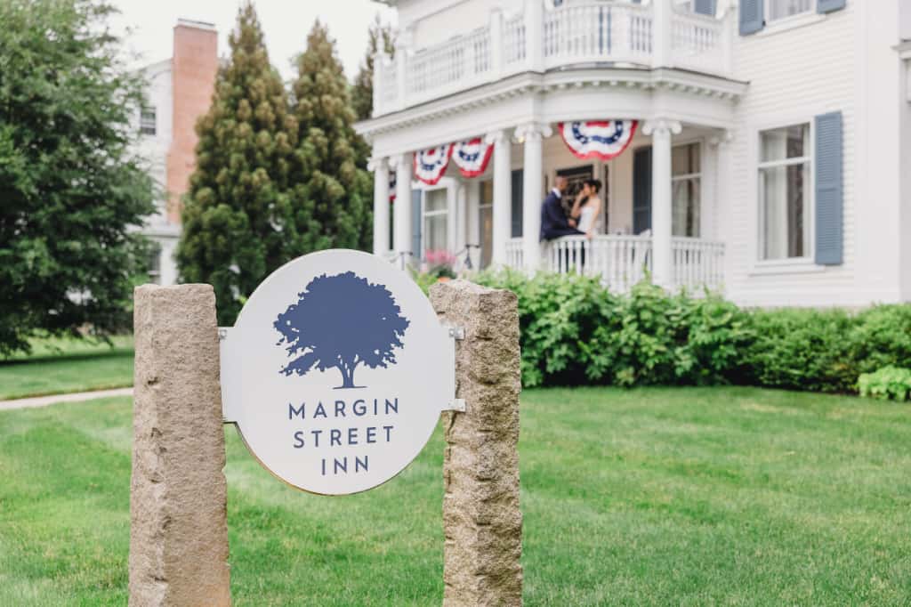 A bride and groom standing on the front porch of our New England bed and breakfast