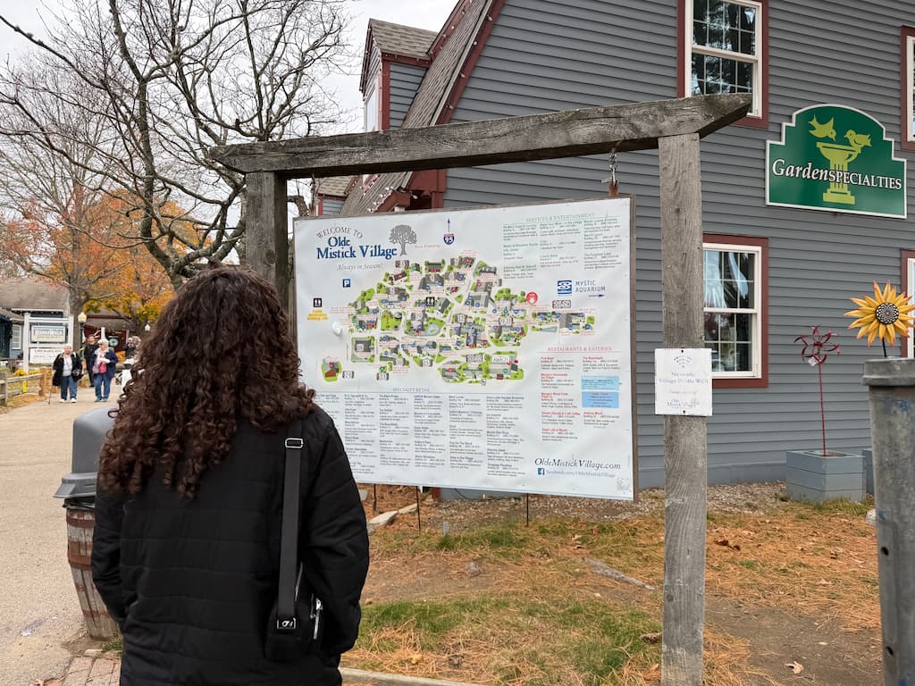 A woman looking at a map directory of Olde Mystic Village